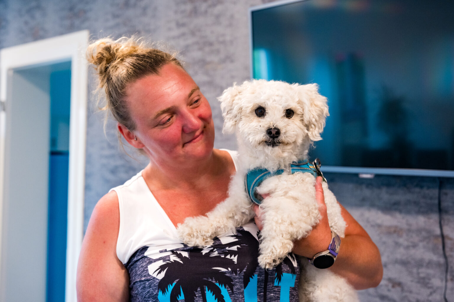 Mitarbeiterin von Janine's Pflegeteam mit einem kleinen Hund auf dem Arm