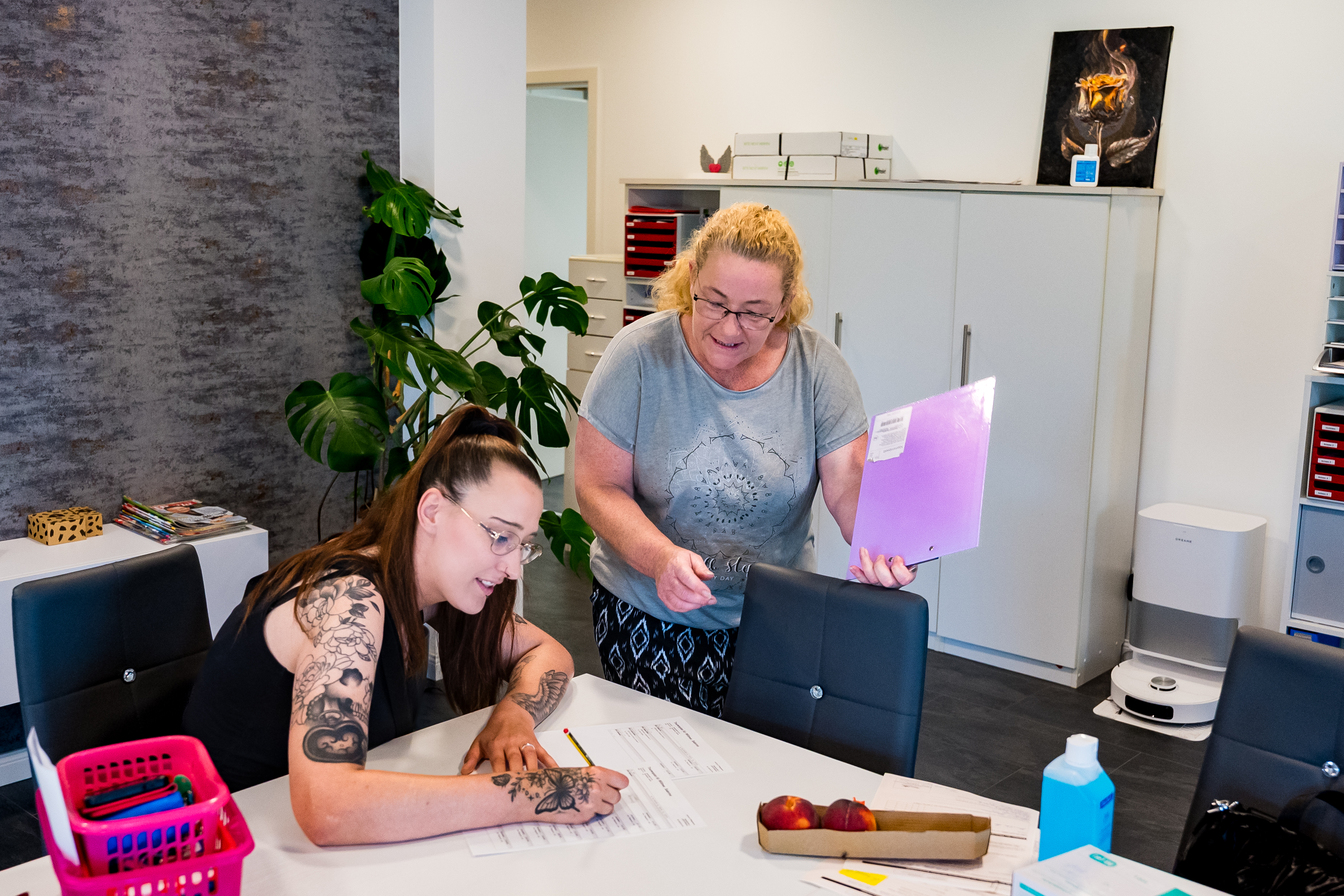 Zwei Mitarbeiterinnen von Janine's Pflegeteam bei der Dienstplanung im Buero